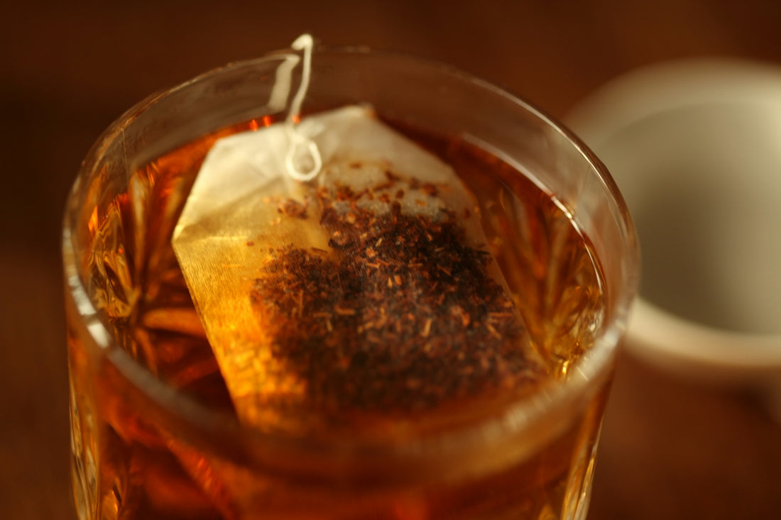 Tea bag steeping in a glass of hot water.