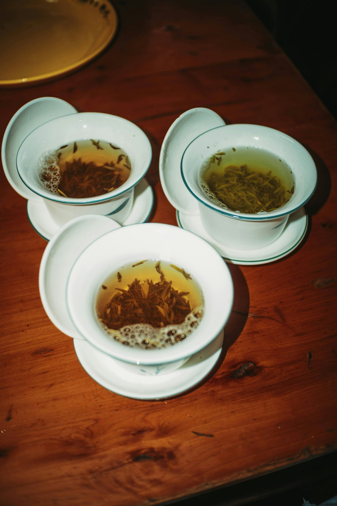 Three cups of hot tea with loose leaves