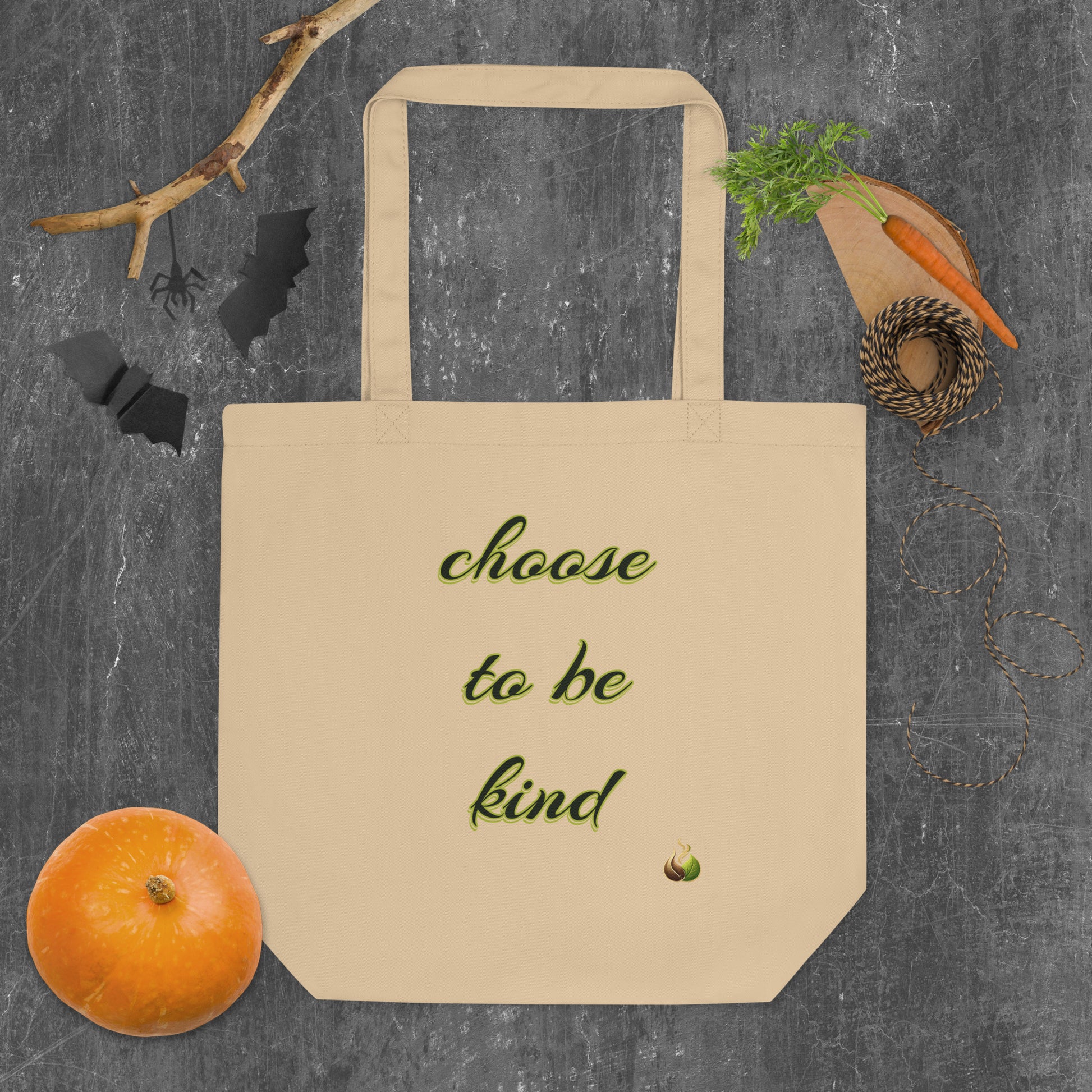 Beige tote bag with 'Animal Care Teams' logo on a gray surface with vegetables and a branch.
