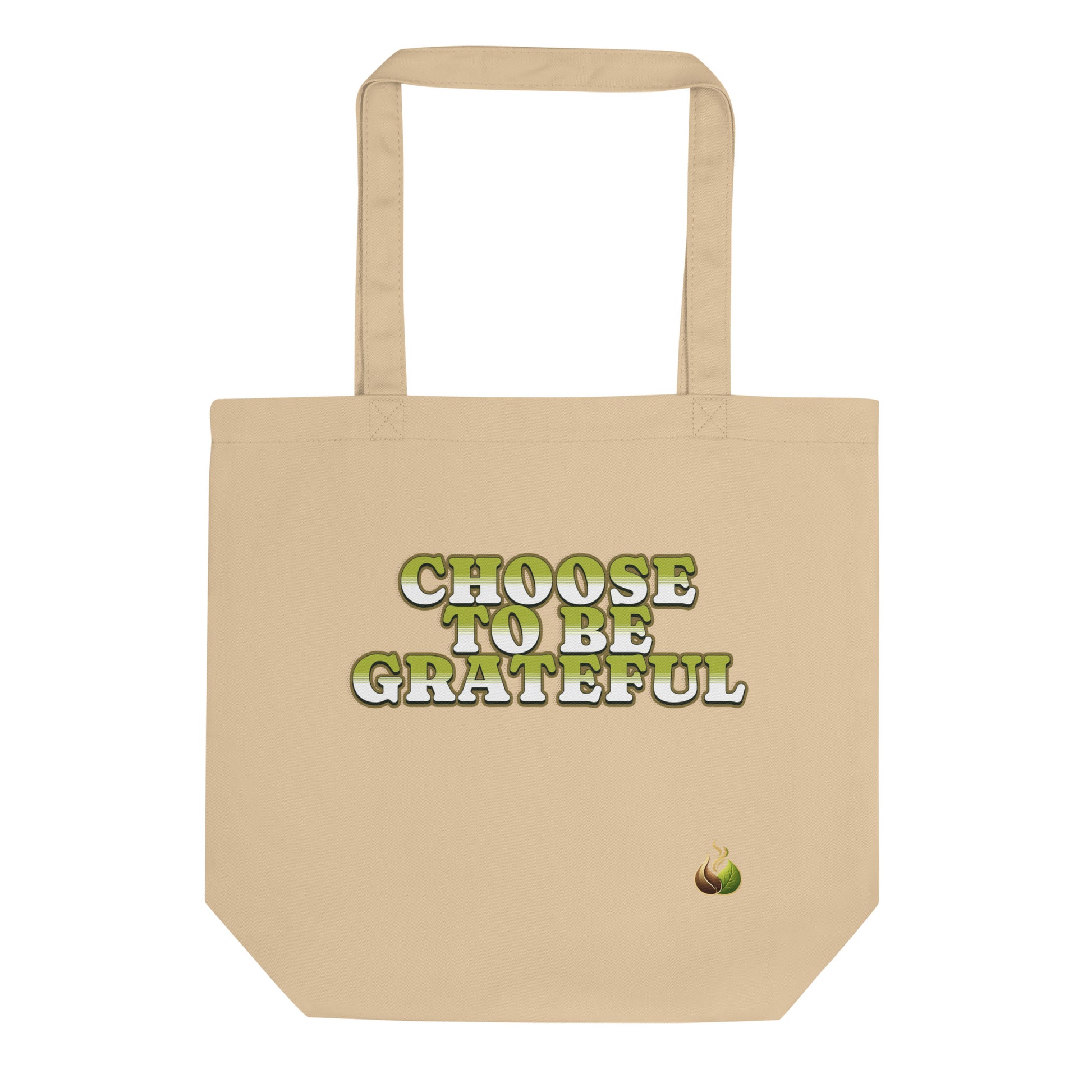 A beige canvas tote bag with the phrase 'CHOOSE TO BE GRATEFUL' printed in green and white text on the front, accompanied by a small avocado graphic near the bottom right corner.