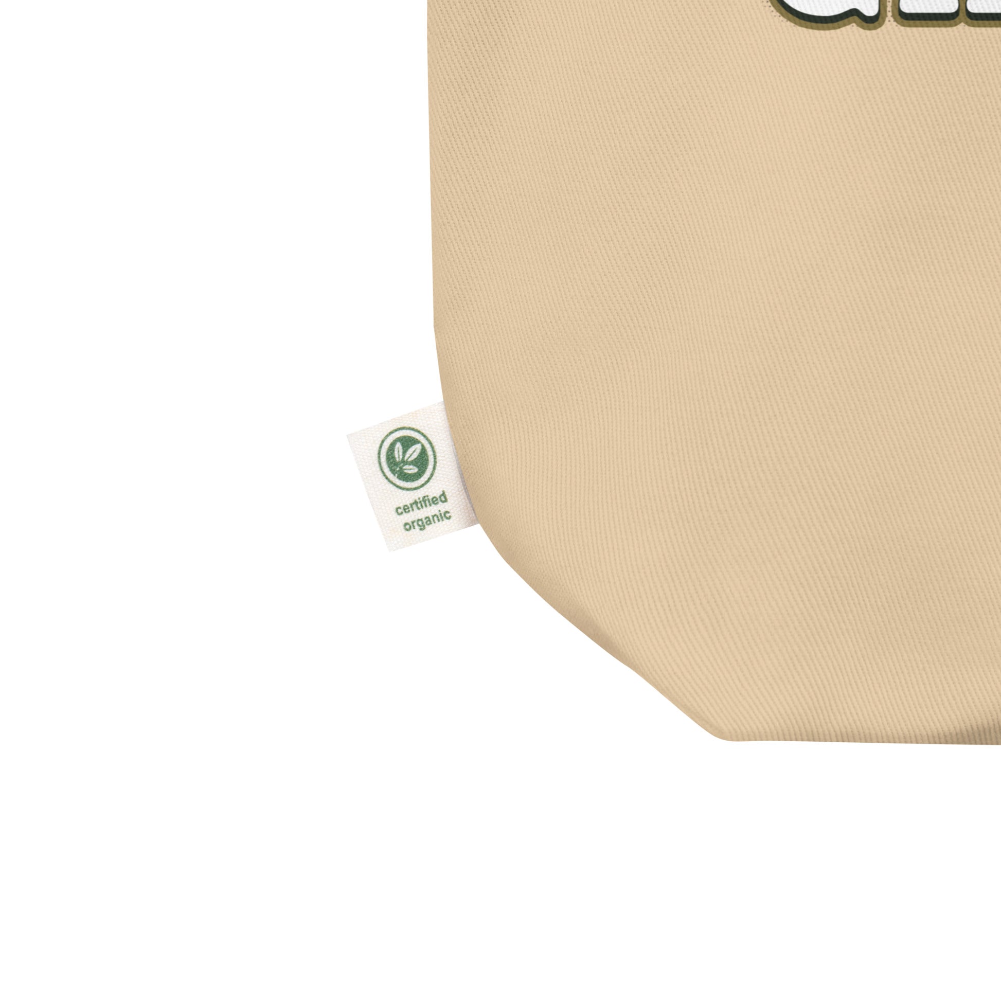 Close-up of a beige fabric product corner with a small white 'certified organic' tag attached, on a white background.
